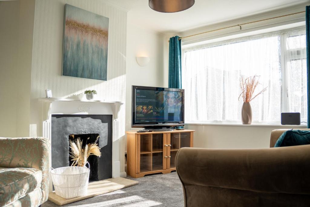 un salon avec une cheminée et une télévision dans l'établissement Well-furnished 3-Bedroom house with Free Parking and Sky TV in Milton Keynes by HP Accommodation, à Milton Keynes