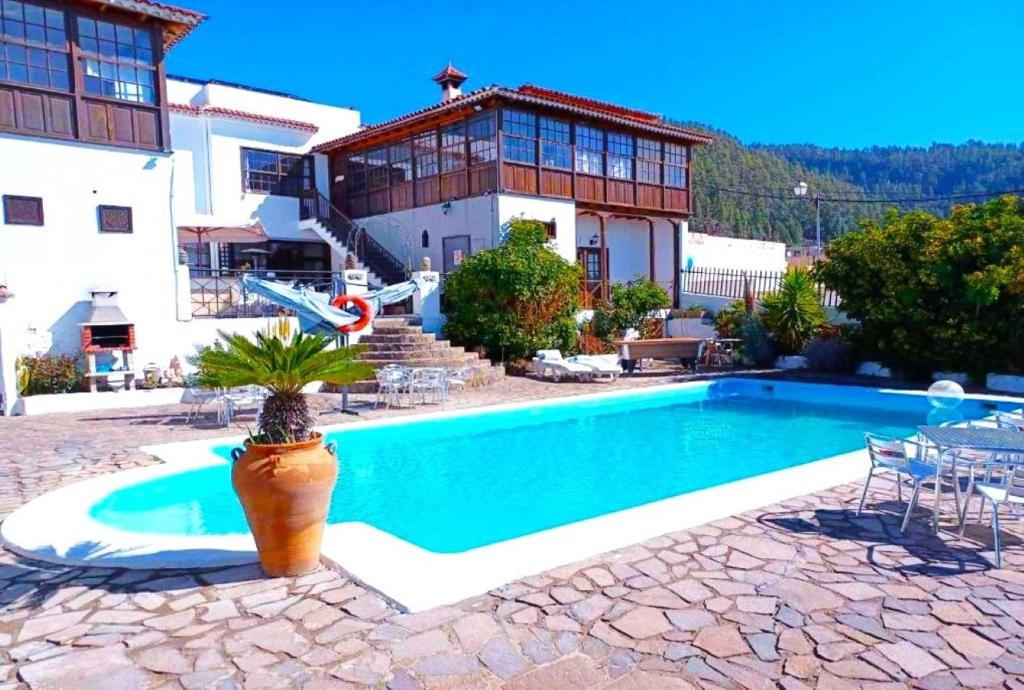 a villa with a swimming pool in front of a house at Ziggys Mountain Retreat in Vilaflor