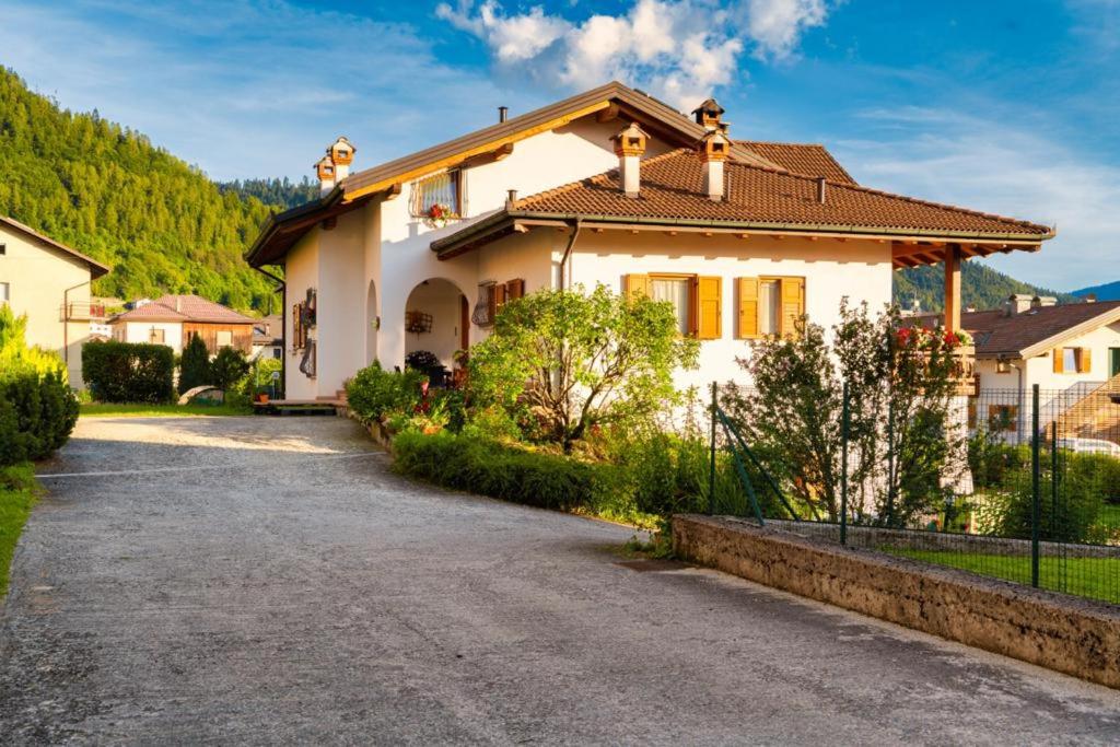 a large white house with a driveway at Villa Floris in Castello Tesino