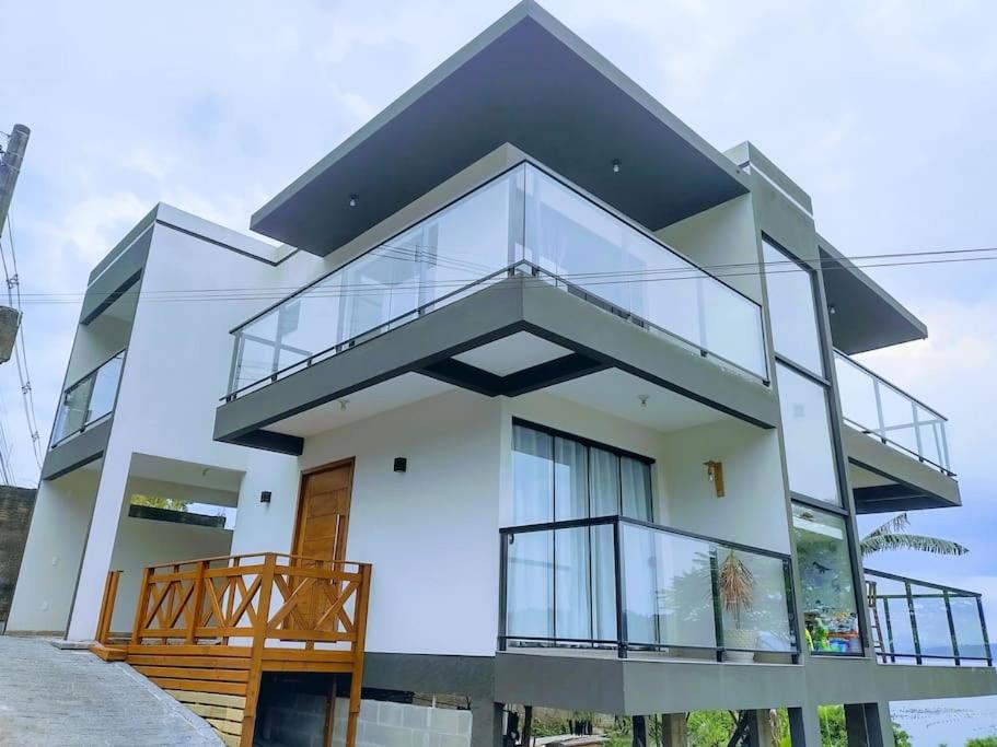 ein Haus mit Glastüren und einem Balkon in der Unterkunft Casa Vista Mar in Governador Celso Ramos