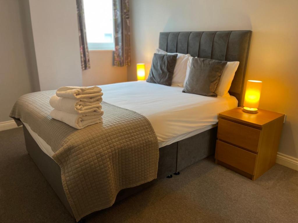 a bedroom with a bed with towels on it at Belgrade Plaza Serviced Apartments in Coventry