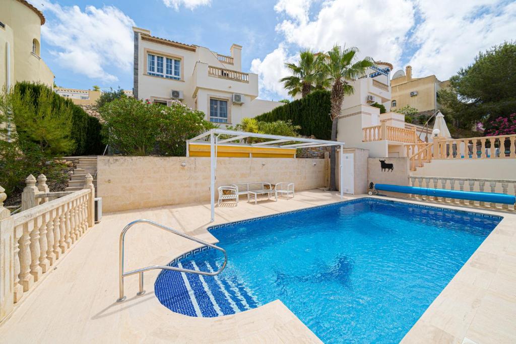 a swimming pool in front of a house at Casa Pia in Orihuela Costa