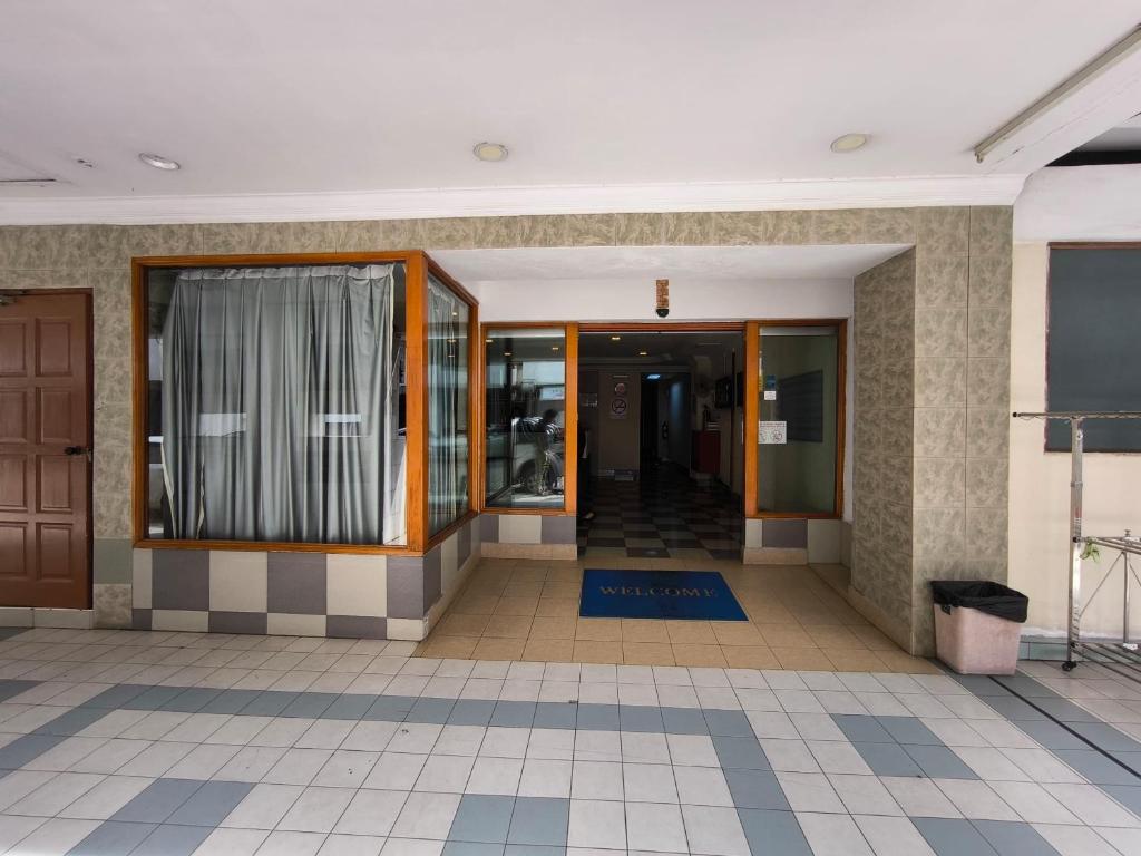 un couloir d'un bâtiment avec des portes en verre dans l'établissement OYO 90895 Hotel Ikia, à Kampong Bagan Dalam