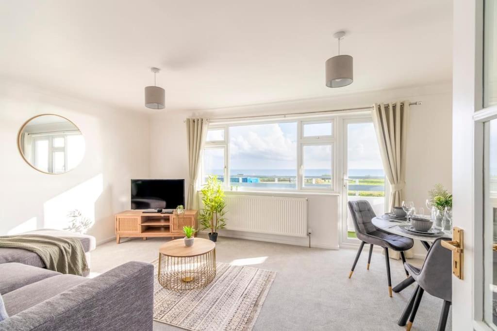 a living room with a couch and a table at Trendy Sea View 2 bedroom Sleeps 6 - Free Parking in Bournemouth