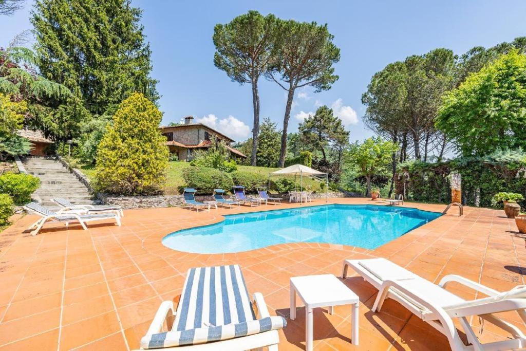 una piscina con tumbonas y una casa en Villa ai Boschetti, en Luciano