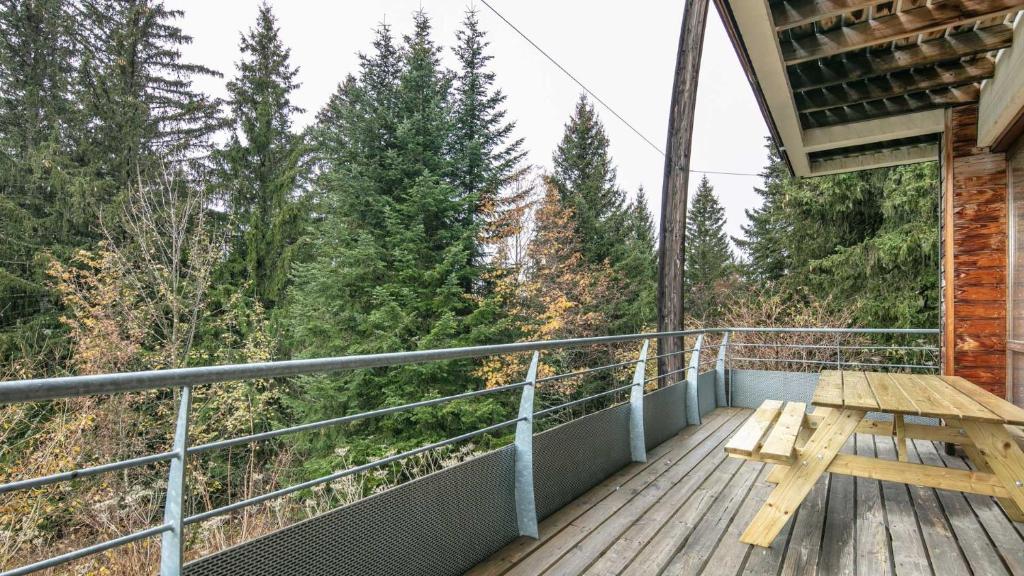 une terrasse en bois avec une table de pique-nique sur un balcon dans l'établissement V du Bachat Joubarbe 1 6 pers, à Chamrousse
