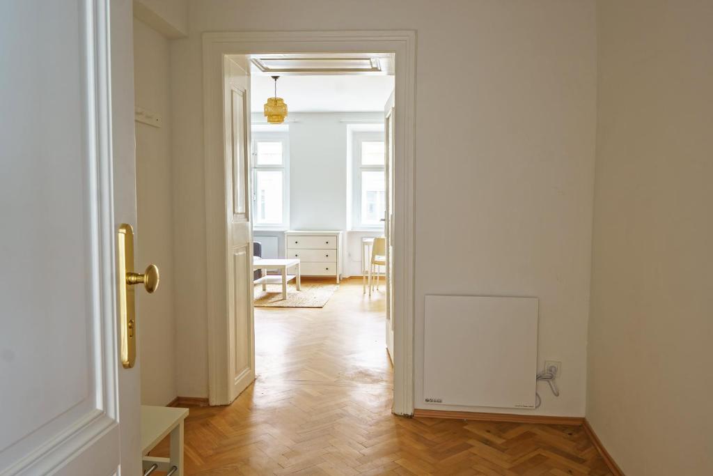 una puerta abierta a una habitación con suelo de madera en Vienna Living Apartments - Barnabitengasse en Viena