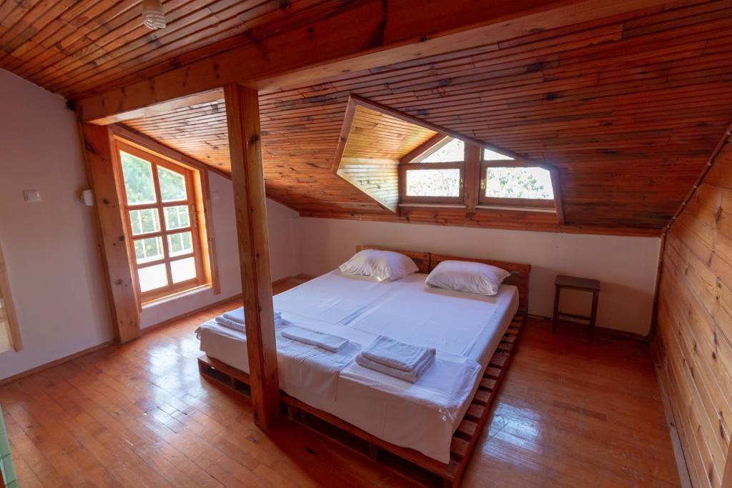 een slaapkamer met een groot bed op een houten zolder bij Deydaa Ekoloji Kampı in Gerze