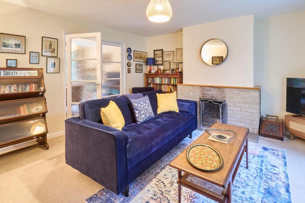 a living room with a blue couch and a fireplace at Host & Stay - Mayfield in Blean