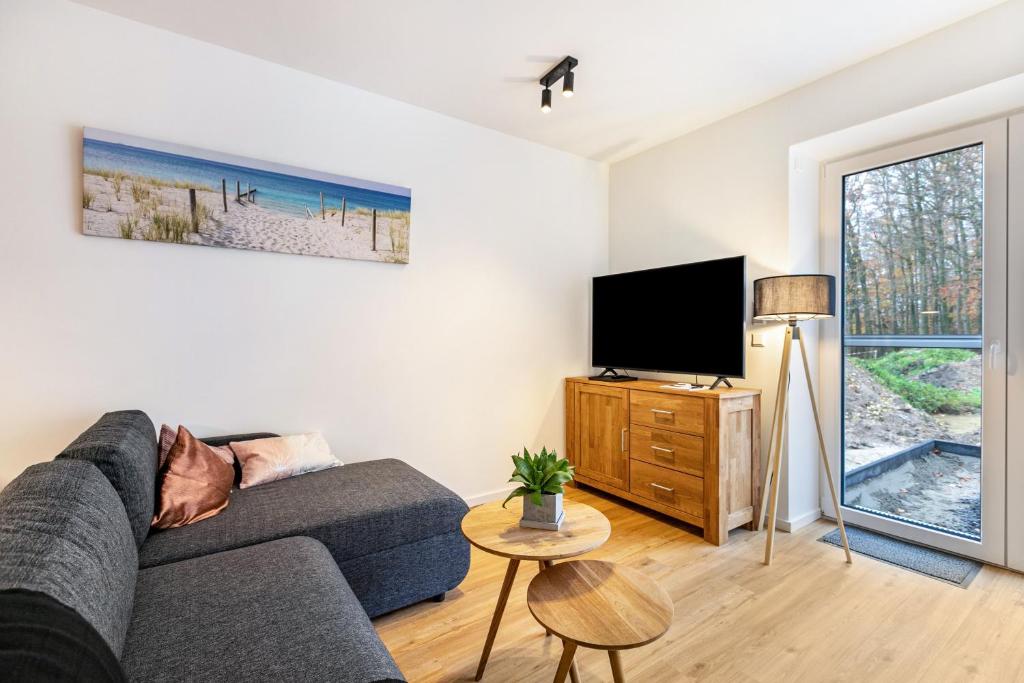 sala de estar con sofá y TV de pantalla plana en Voldewraa Wohnung 5 en Husby