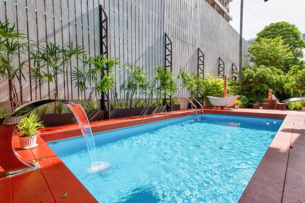 a swimming pool with a fountain on a building at Sathorn Private Pool Villa in Bangkok