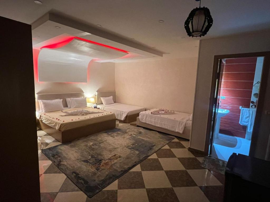een kamer met 2 bedden en een geruite vloer bij pyravista in ‘Ezbet `Abd el-Ḥamîd