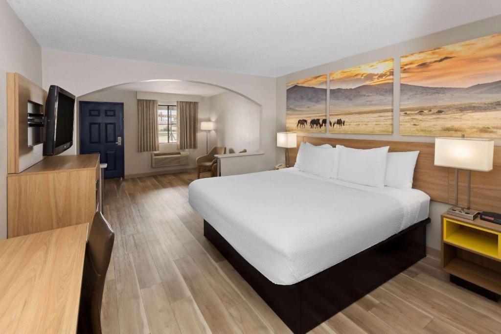 オクラホマシティにあるDays Inn by Wyndham Oklahoma Cityのホテルルーム内の大きな白いベッド