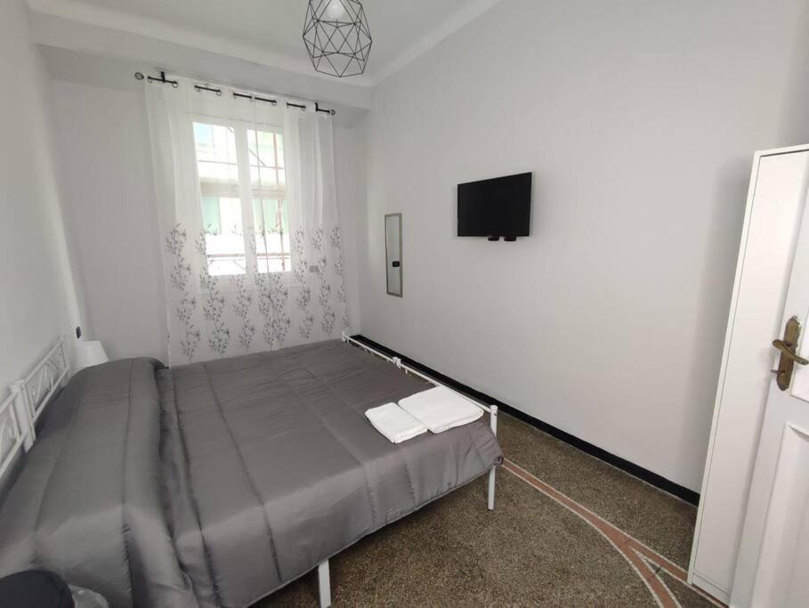 a bedroom with a bed and a flat screen tv at Benny appartamento 3 CAMERE DA LETTO ad uso ESCLUSIVO Genova Aeroporto in Genoa