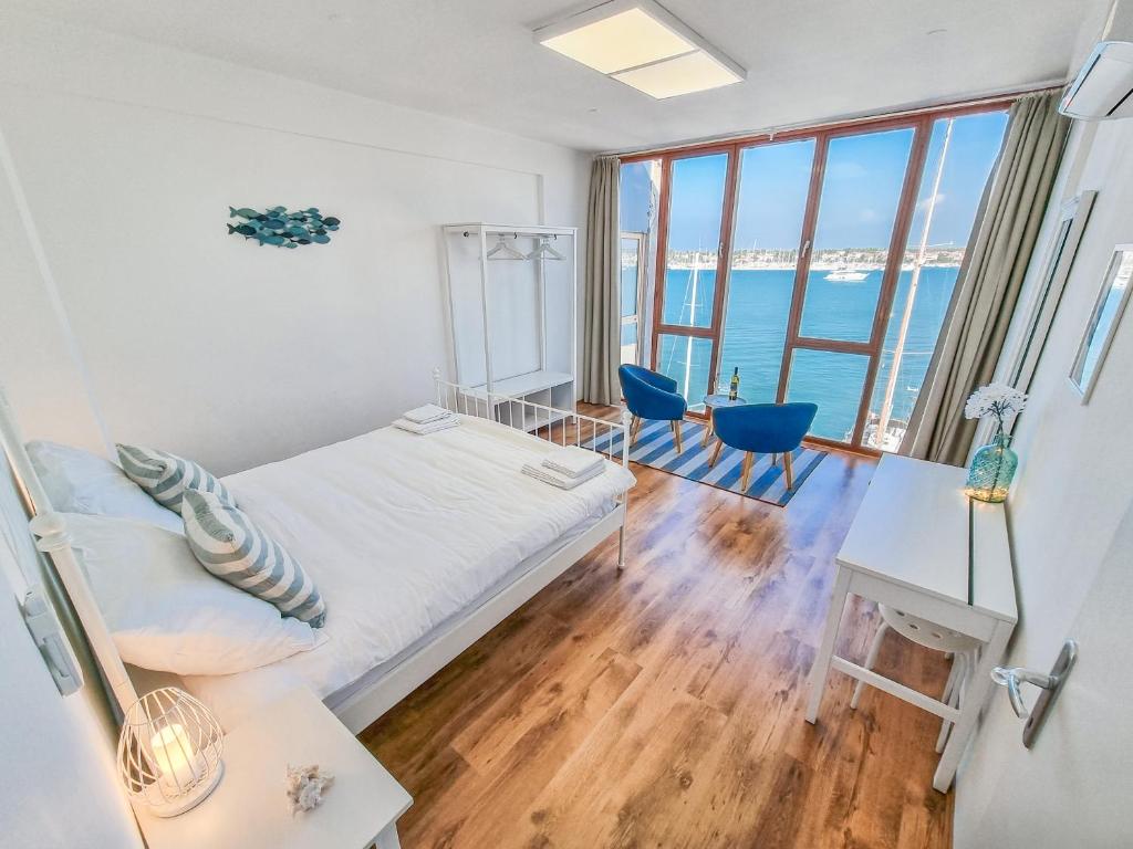 a bedroom with a bed and a desk with a desk at Umag center seafront seaview old town apartment rentistra 1 in Umag