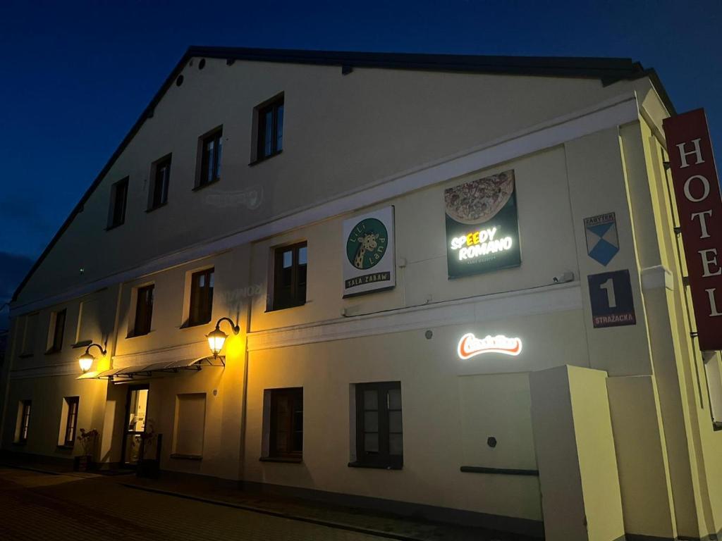 a white building with signs on the side of it at Hotel Colnus in Kolno
