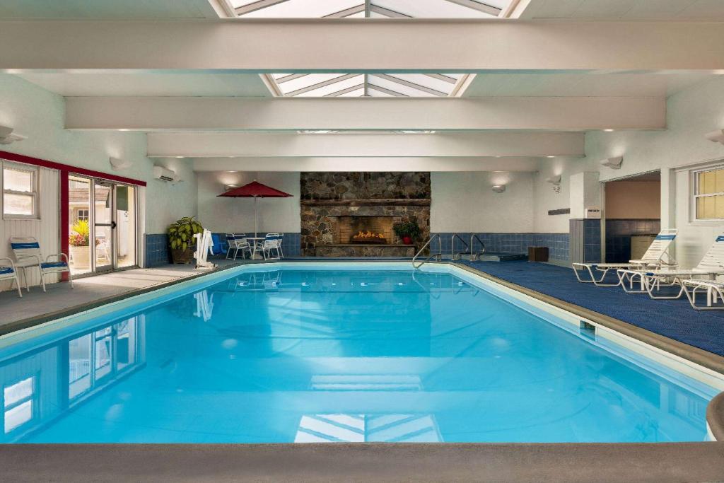 a large swimming pool with blue water in a building at Ramada Plaza by Wyndham Portland in Portland