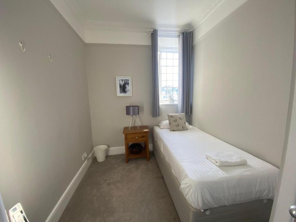 a small bedroom with two beds and a window at Crowcombe Court in Crowcombe