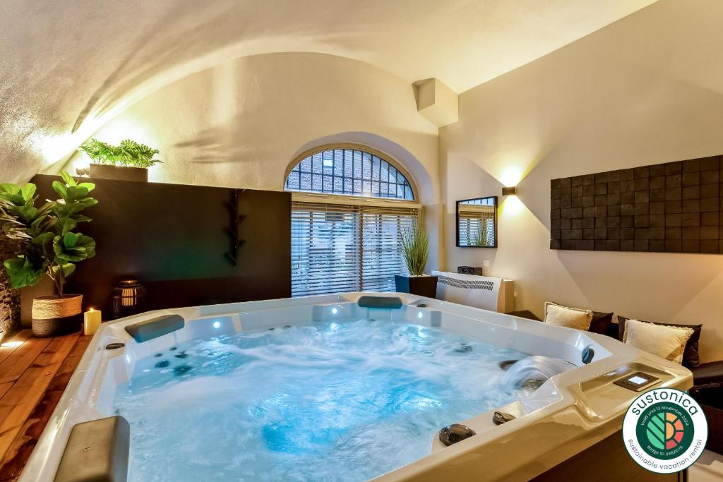eine große Badewanne in einem Zimmer mit einem großen Fenster in der Unterkunft Le Chicissime, coeur du village, LLA Selections by Location lac Annecy in Talloires