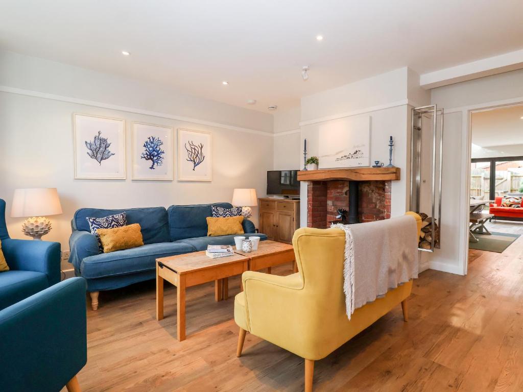 ein Wohnzimmer mit einem blauen Sofa und einem Tisch in der Unterkunft Fawcett Cottage in Aldeburgh