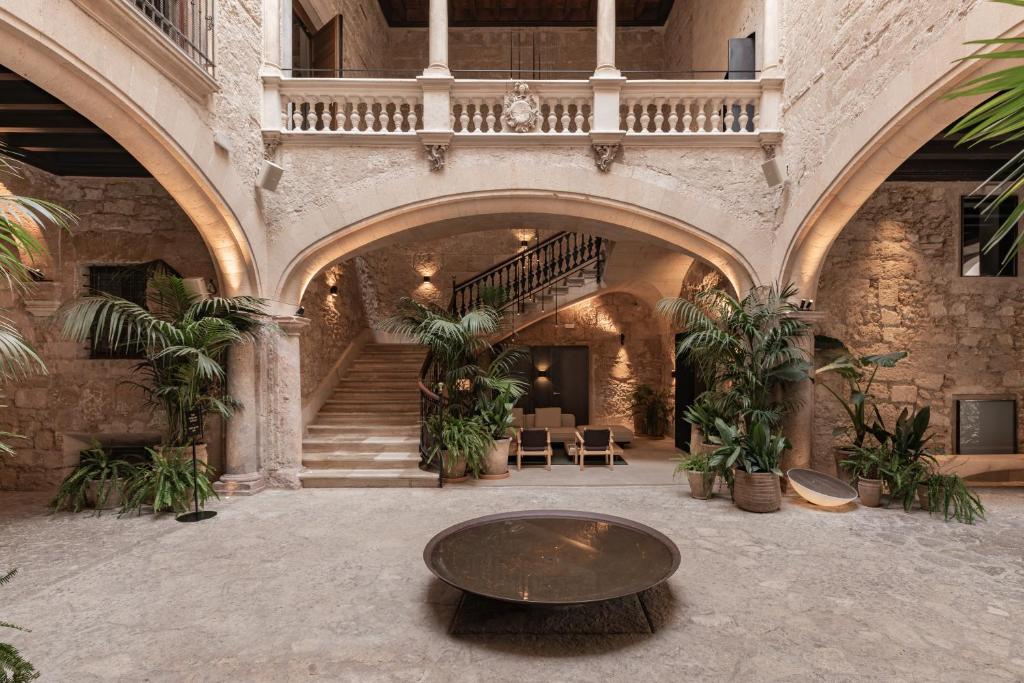 a room with a staircase and a table in a building at Nobis Hotel Palma, a Member of Design Hotels in Palma de Mallorca