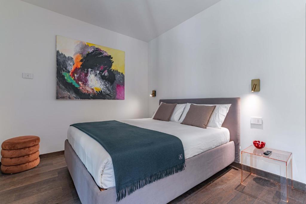 a bedroom with a bed and a painting on the wall at Luxury apartment - Free Parking - Duomo-Navigli in Milan