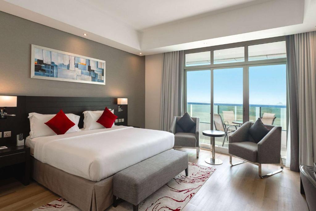 pokój hotelowy z łóżkiem i dużym oknem w obiekcie Ramada by Wyndham Dubai Barsha Heights w Dubaju