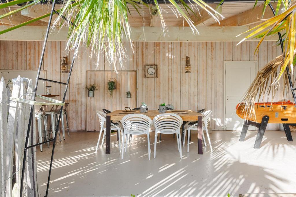 ein Esszimmer mit einem Holztisch und Stühlen in der Unterkunft Villa la forge expérience bien-être in Nuaillé-dʼAunis