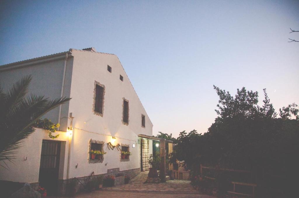 a white building with lights on the side of it at CORTIJO COLOMO in Almedinilla