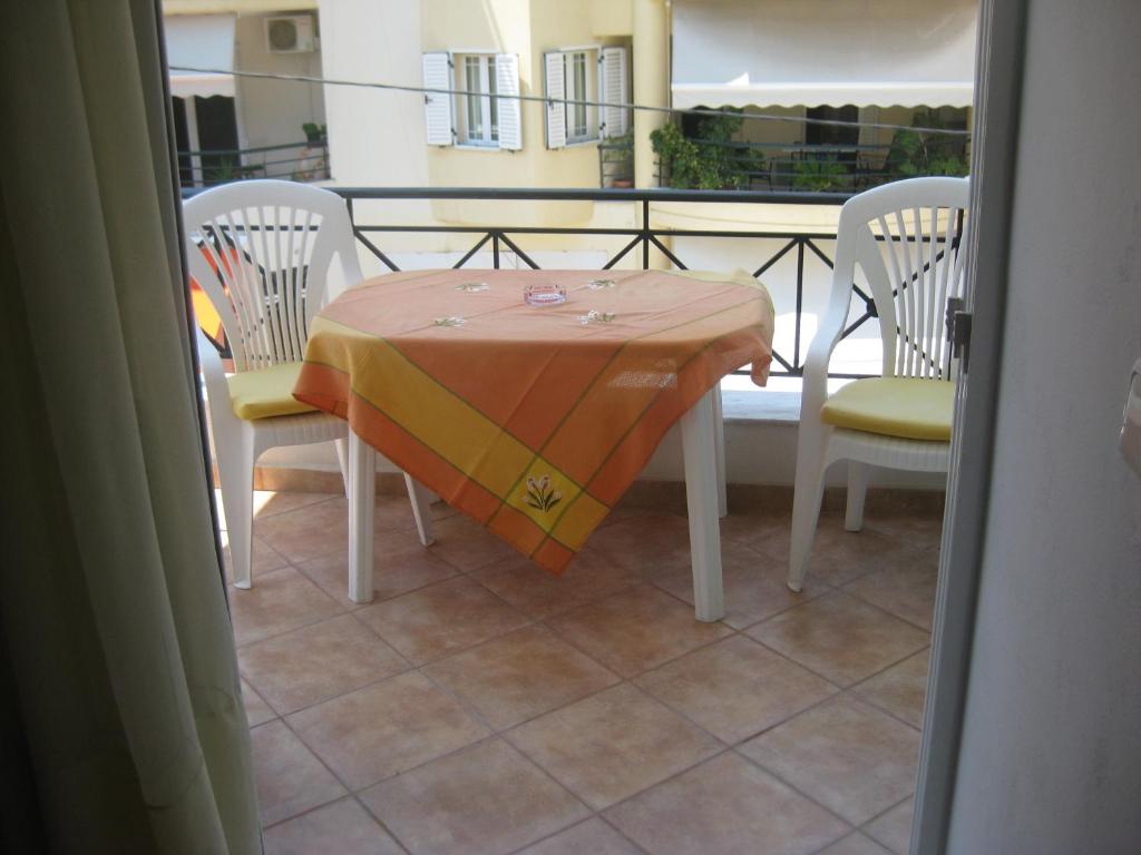 uma mesa e cadeiras com uma toalha de mesa numa varanda em Agalos Studios em Loutra Edipsou