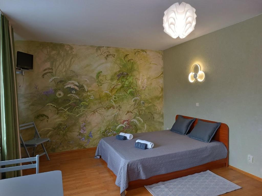 ein Schlafzimmer mit einem Bett und einem Wandgemälde in der Unterkunft Вілла На Гірській in Schidnyzja