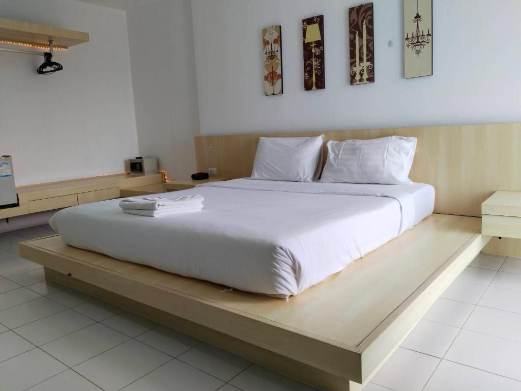 a bedroom with a large white bed on a wooden platform at Urban Patong Residence in Patong Beach
