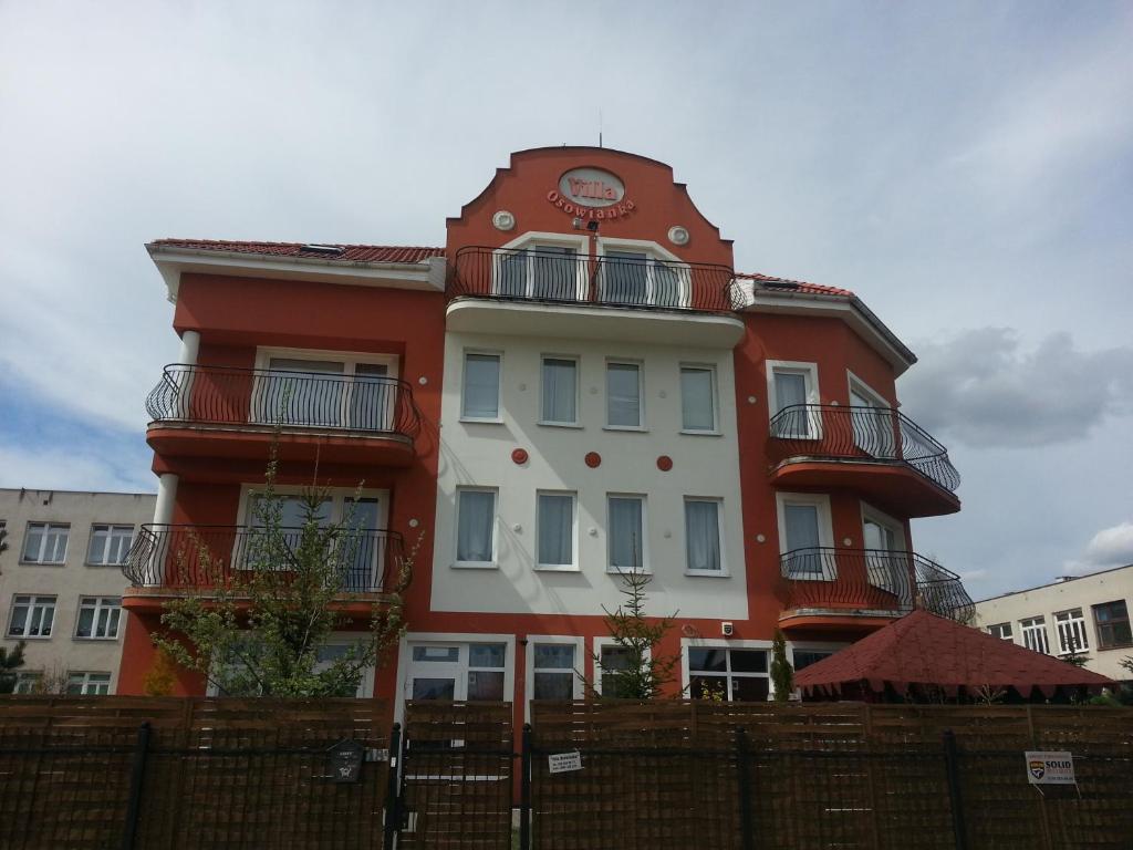 a red and white building with a clock on it at Villa Osowianka in Gdańsk