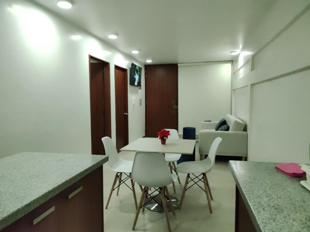 a kitchen with a table and chairs in a room at Hermoso departamento piso 1 in Loja