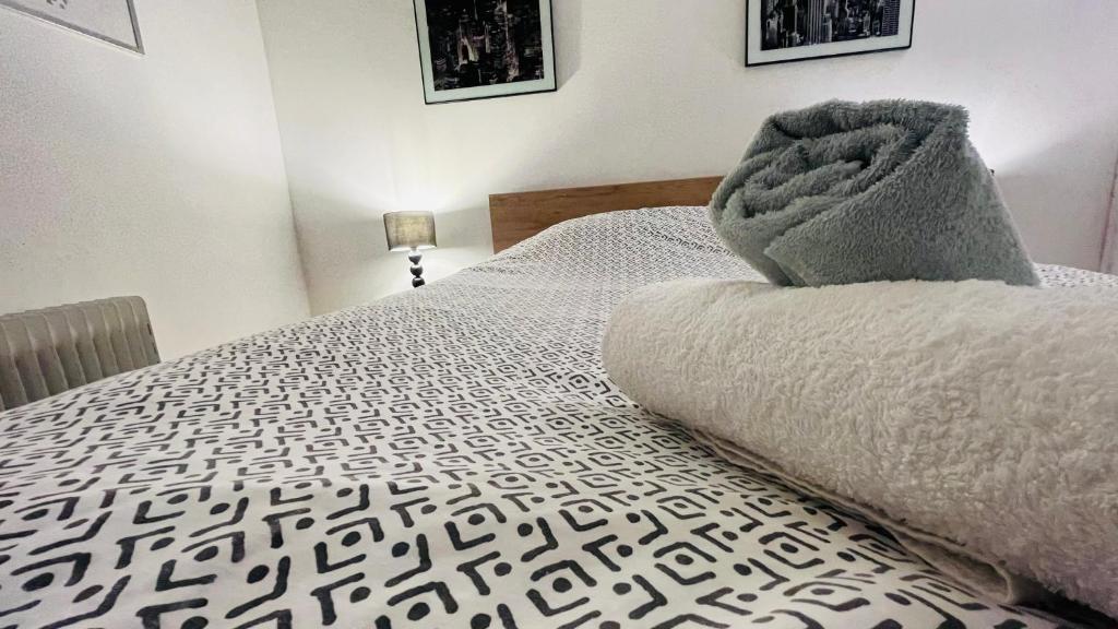 a bedroom with a bed with a blanket on it at Le Grand Noble -Tram-Parking-Wifi in Blagnac