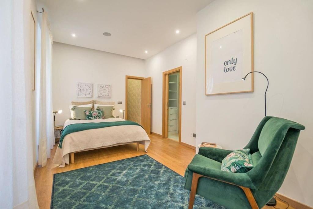 ein Schlafzimmer mit einem Bett und einem grünen Stuhl in der Unterkunft Lisbon Lapa Flat w/ Patio in Lissabon