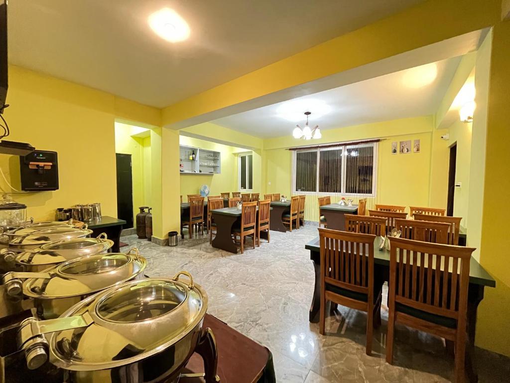 a large room with tables and chairs and a cafeteria at Little Sikkim Inn in Gangtok