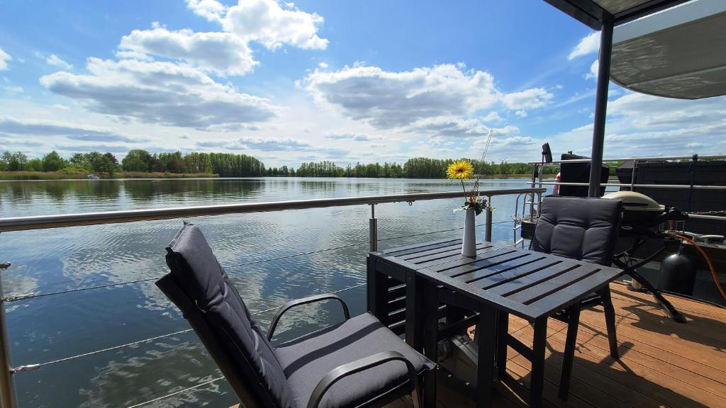 Hausboot Joana في تسيهدينك: طاولة وكراسي على قارب على الماء