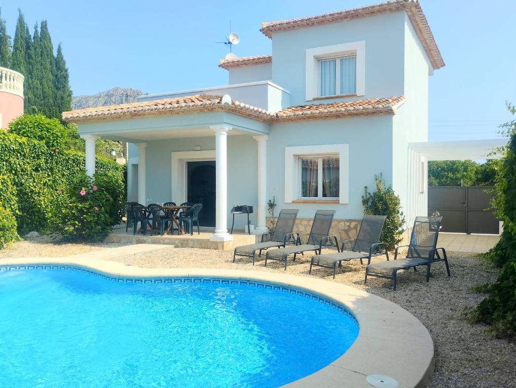 a villa with a swimming pool in front of a house at Villas Benicadims - BTB in Beniarbeig