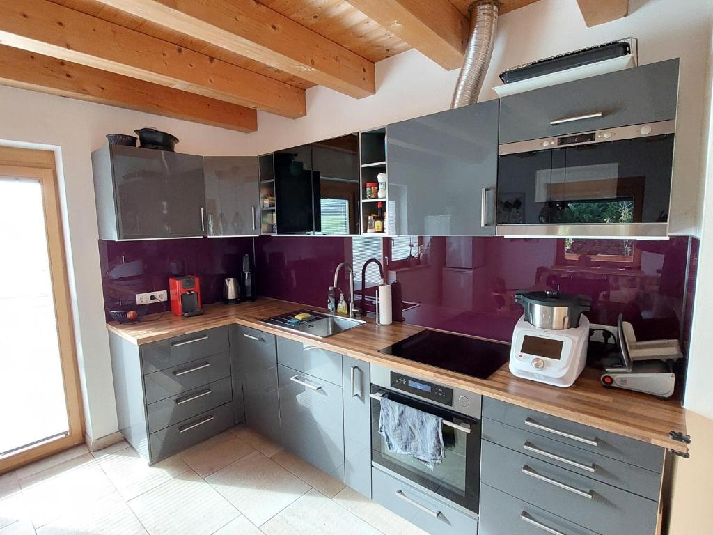 a kitchen with purple cabinets and a counter top at Ferienwohnung am Arzberg in Schwaz