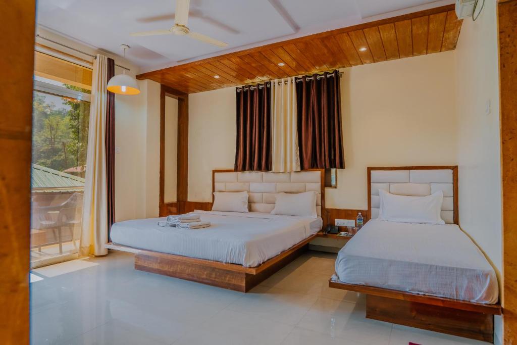 1 dormitorio con 2 camas y ventana en oakwood mahabaleshwar, en Mahabaleshwar