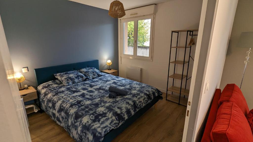 sypialnia z niebieskim łóżkiem i oknem w obiekcie Studio Parc Carrières Bacquin à 5 minutes de la gare w mieście Dijon
