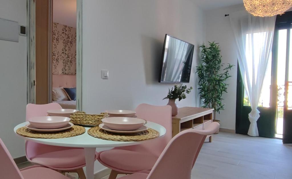 comedor con mesa y sillas rosas en Alojamientos Rurales Las Candelas en Santa Marta de Magasca