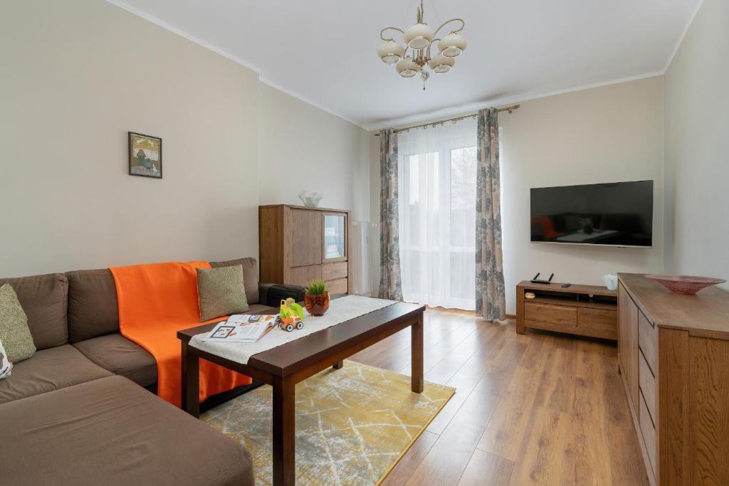 sala de estar con sofá y mesa en Traditionally Furnished Apartment with Balcony in Poznan by Renters en Poznan