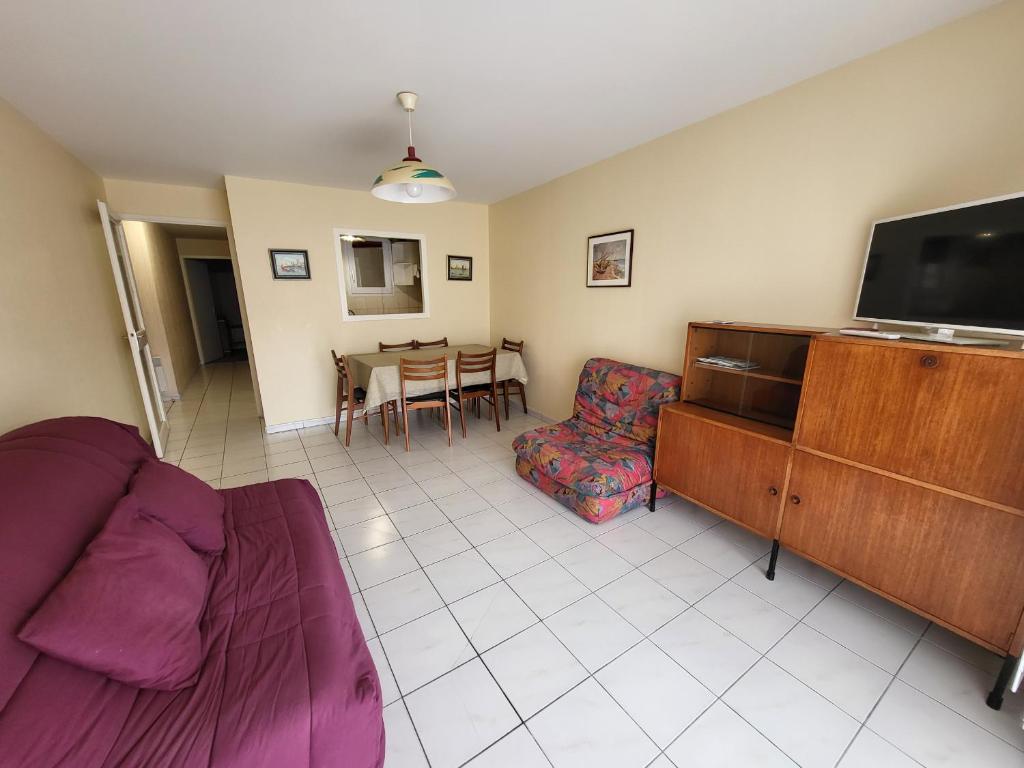 een woonkamer met een bank, een tv en een tafel bij Appartement Les Sables-d'Olonne, 2 pièces, 4 personnes - FR-1-92-575 in Les Sables-dʼOlonne