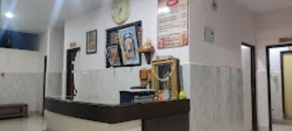 a lobby with a counter and a clock on a wall at Hotel YOGIRAJ LODGING BOARDIING,Deulgaon Raja 