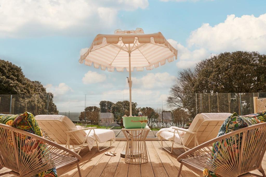 a patio with a table and chairs and an umbrella at The Nici in Bournemouth