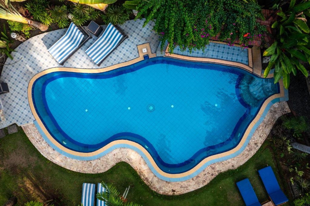 an overhead view of a swimming pool with chaise lounge chairs at Lombok Stanley Garden Villas in Montongbuwoh