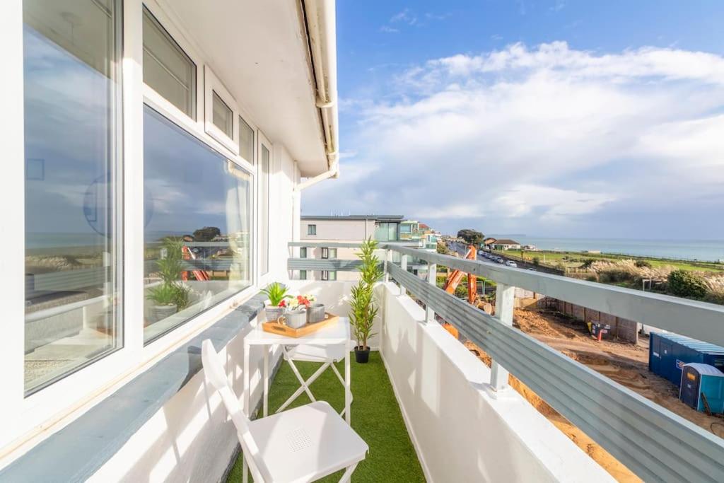uma varanda com mesa e cadeiras e vista para o oceano em Breath Taking Sea View 2 bedroom Sleeps 6- Parking em Bournemouth