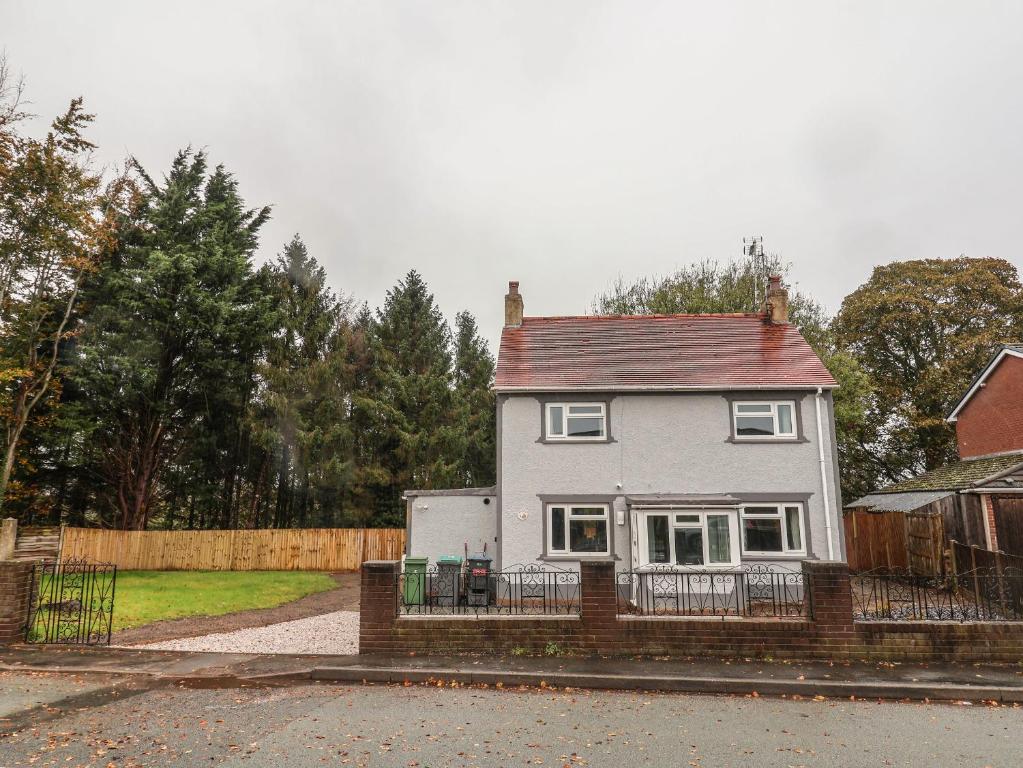 a white house with a fence in front of it at Woodside in Wrexham